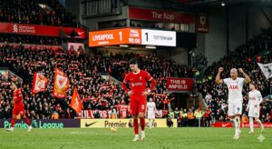 Score final 1-1 affiché sur l'écran géant d'Anfield entre Liverpool et Tottenham, joueurs sur le terrain.